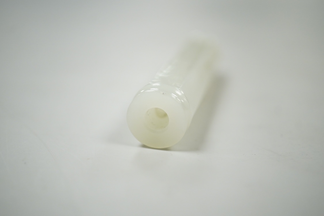 A Chinese pale celadon jade inscribed cylinder bead, 6.5cm long